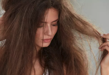 Woman looking at her damaged split ends